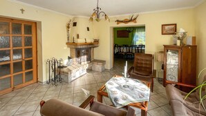 Una sala de estar acogedora con chimenea, un comedor y una cocina visible a través de una puerta abierta.