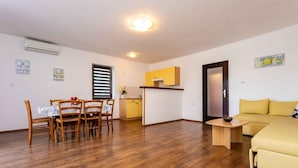 Un espacio habitable compacto con comedor, kitchenette y sofá.