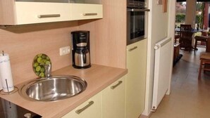 A kitchen with a stainless steel sink, a coffee maker, and a built-in oven. - Tern (House 167) - FH 167 (Mönkebude)