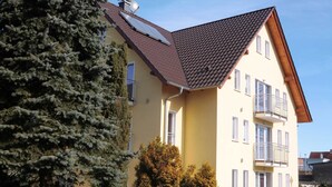 A two-story building with a sloped roof, solar panels, and a balcony. - Double room 4 - PENSION Delia Will in Ahlbeck (Heringsdorf)