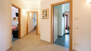 A hallway with a tiled floor, wooden doors, and framed artwork on the walls. - Beautiful home in Rende -CS- with WiFi (Rende -CS-)