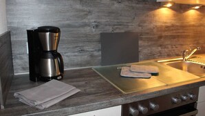 A kitchen with a coffee maker, a sink, and a stove. - Apartment - Holiday apartments Haus Waldesruh (Edertal)