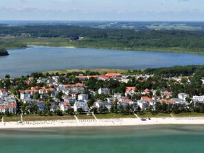 A coastal town with a beach, houses with red roofs, and a large body of water. - House Emsland 3 - house Emsland (Binz)