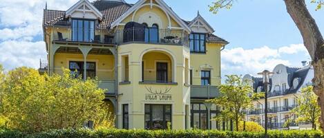 A yellow building with balconies and a sign that reads 'Villa Laura.'