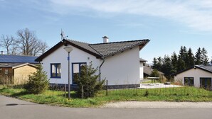A single-story house with a sloped roof, a satellite dish, and solar panels. - Amazing home in Gerolstein with kitchen (Gerolstein)
