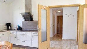 A modern kitchen with a built-in stove, a coffee maker, and a striped chair. - Amazing home in Gerolstein with kitchen (Gerolstein)