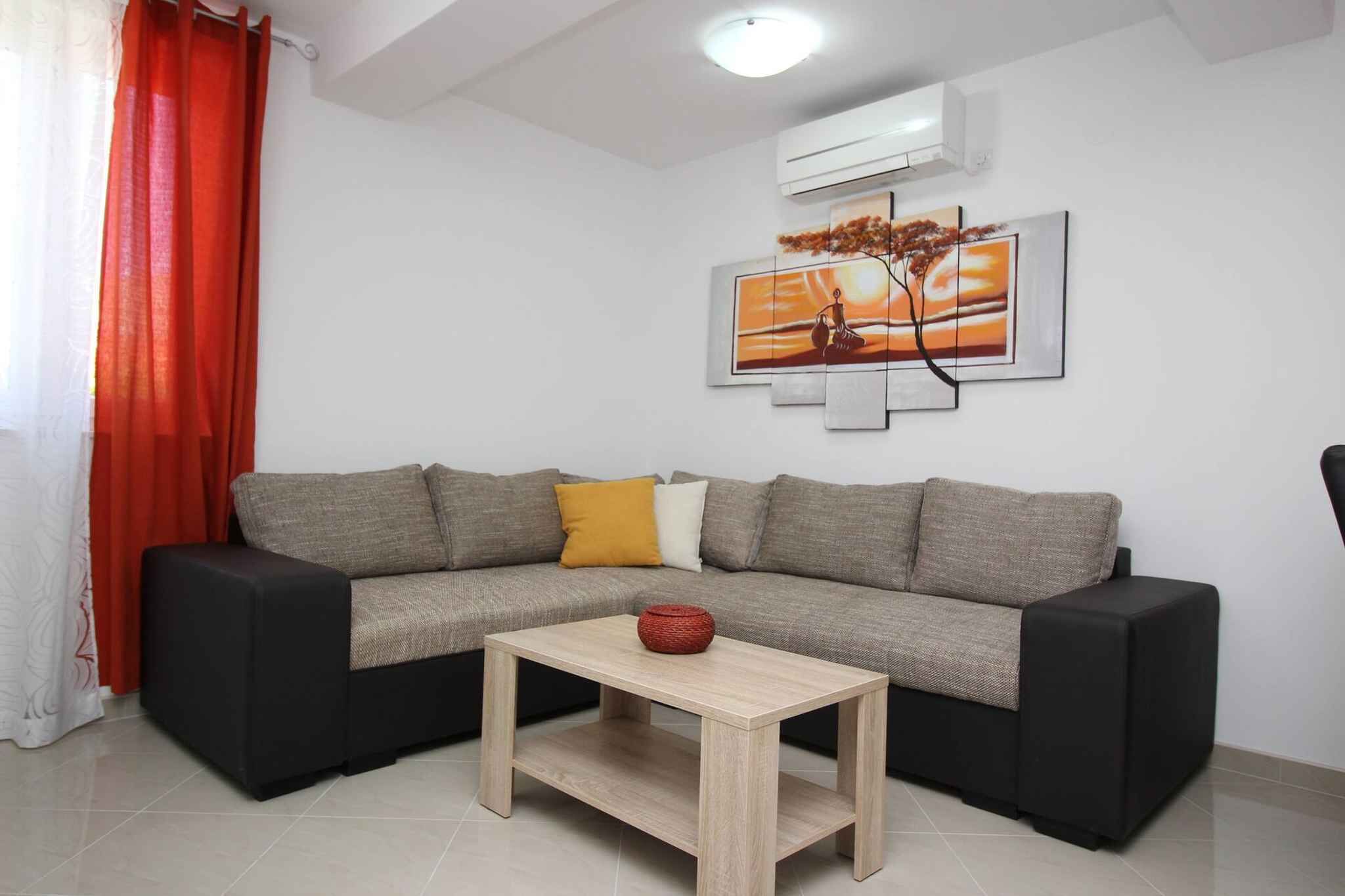 A living room with a sectional sofa, a coffee table, a wall-mounted painting, and a red curtain.