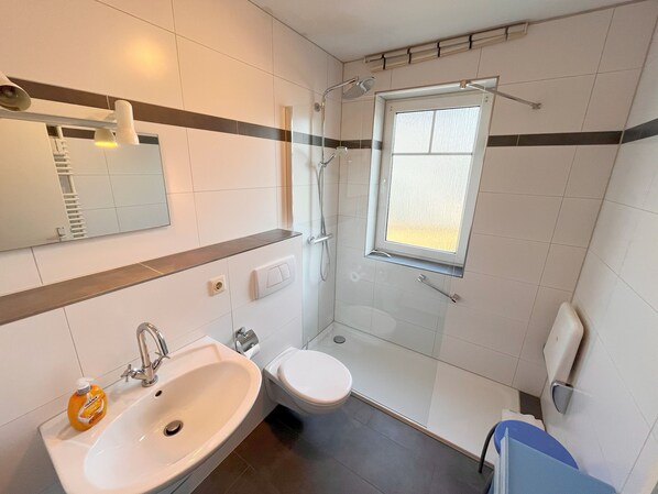 Un baño moderno con ducha, inodoro y lavamanos.