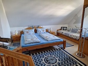 A bedroom with a wooden bed, two bedside tables, a nightstand, a floor lamp, and a patterned rug.