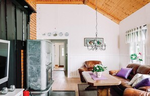 A spacious living room with a fireplace, leather sofa, and a dining table. - 2 bedroom cozy home in Lyrestad (Lyrestad)