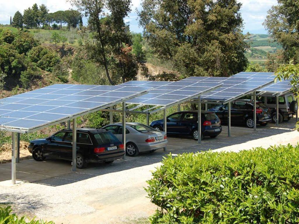 Un parking équipé de panneaux solaires et où sont garées des voitures.