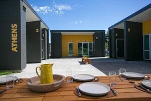 Una piscina al aire libre, sombrillas, sillones reclinables de piscina