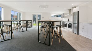 A modern kitchen with stainless steel appliances, a central island, and bar stools.