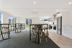 A modern kitchen with stainless steel appliances, a central island, and bar stools.