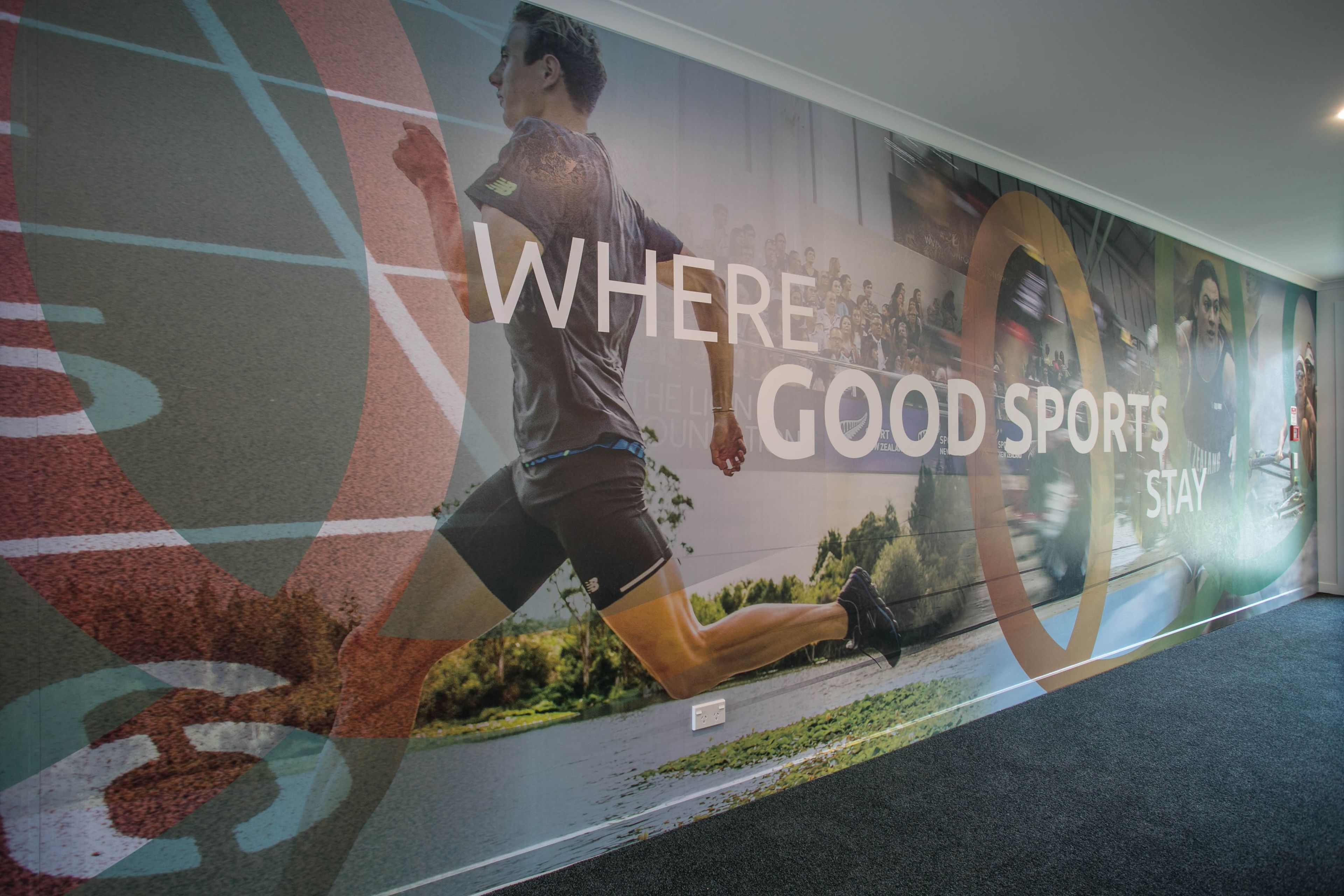 A wall with a running man and the text "WHERE GOOD SPORTS STAY".