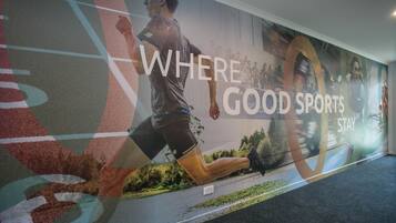 A wall with a running man and the text "WHERE GOOD SPORTS STAY".