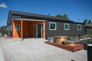 A modern building with a reception area, outdoor seating, and a hot tub.
