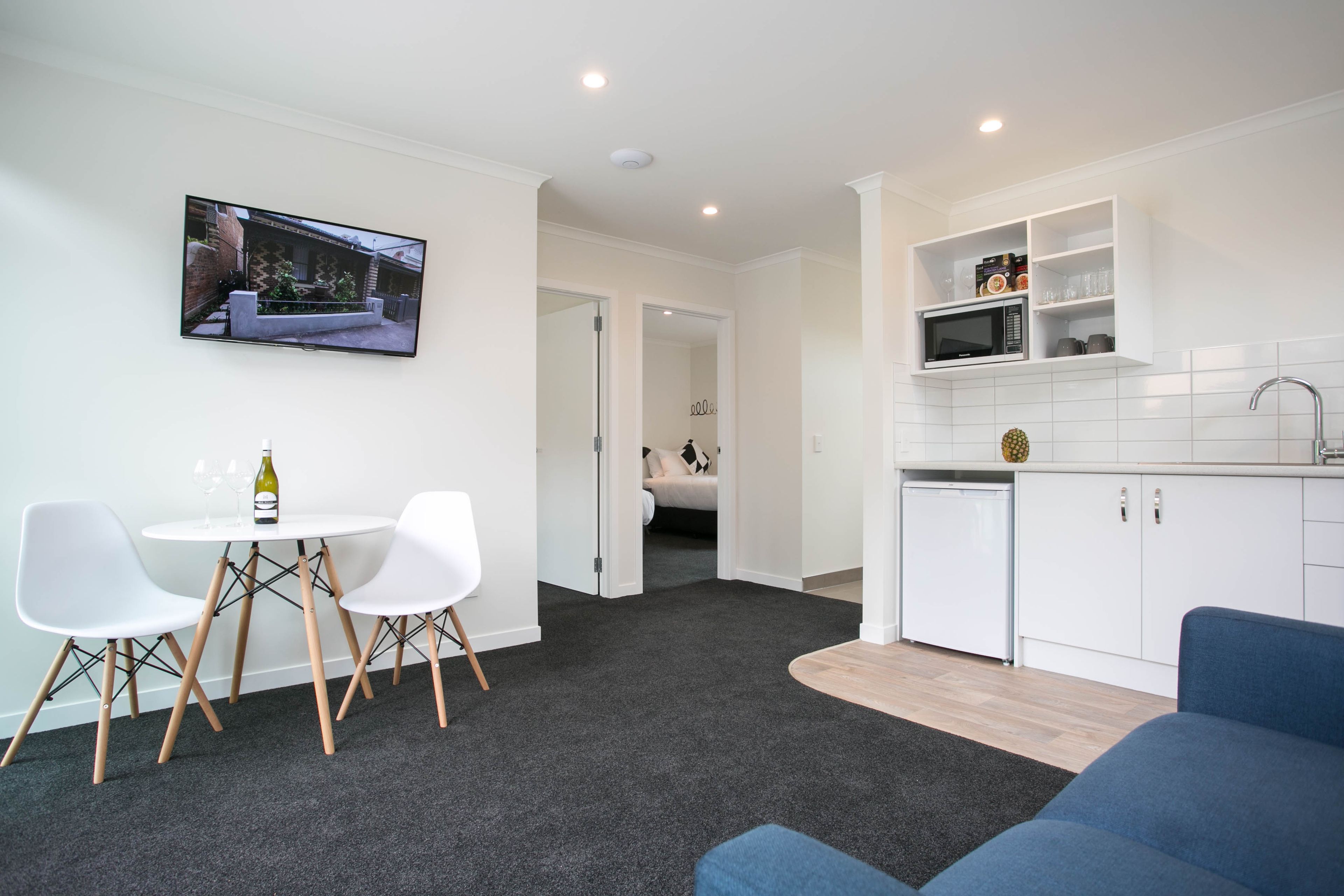 A compact living space with a dining area, a kitchenette, and a bedroom.
