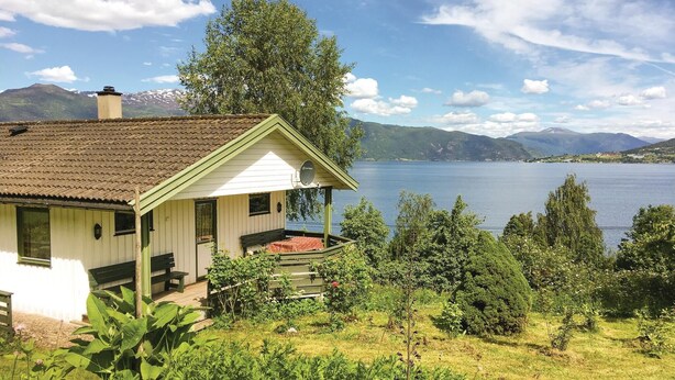 A house with a balcony overlooking a lake, surrounded by greenery and mountains. - 2 bedroom beautiful home in Balestrand (Balestrand)