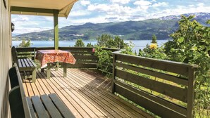 A wooden deck with a table and benches overlooking a lake and mountains. - 2 bedroom beautiful home in Balestrand (Balestrand)
