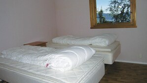 A bedroom with two single beds, a nightstand, and a window with a view of trees and mountains. - 2 bedroom beautiful home in Balestrand (Balestrand)