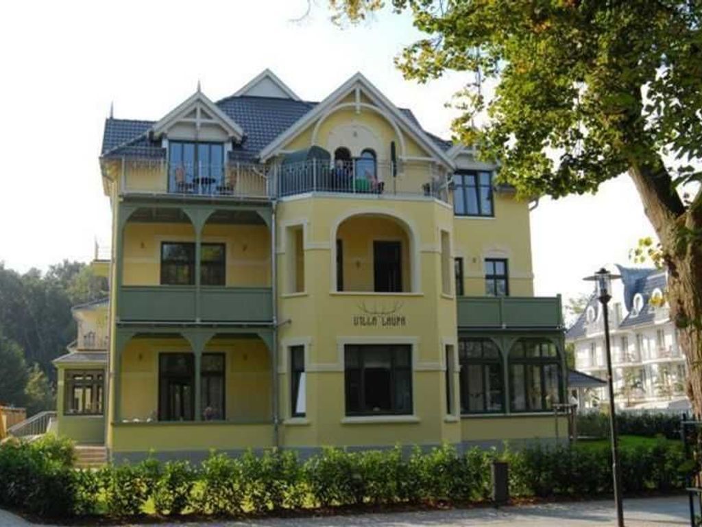 Un edificio de varios pisos con fachada amarilla, balcones y ventanas en arco.