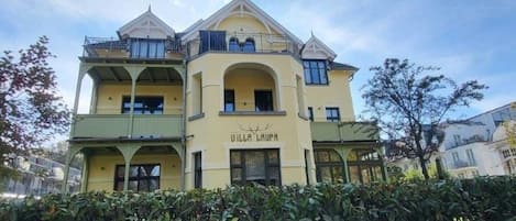 A multi-story building with a prominent arched entrance and balconies.