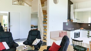 Ein modernes Interieur mit Wohnbereich, Treppe und Küche.