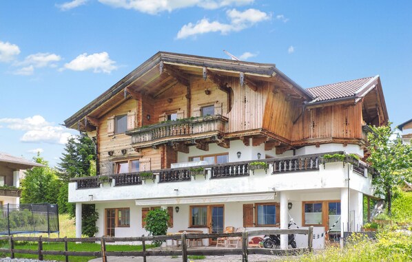 En traditionell stuga i trä med flera balkonger, en inglasad veranda och utsikt över den omgivande naturen.