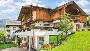 A traditional wooden chalet with balconies, a covered patio, and a view of the mountains. - Ferienwohnung - Hoch Pustertal (Kartitsch)