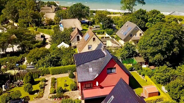Et boligområde med huse, en have og havudsigt.