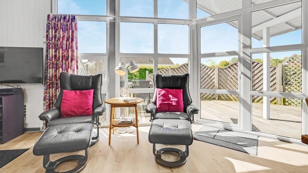 A modern room with two reclining chairs, a small table, and a TV. - Beautiful home in Sydals with sauna (Sydals)