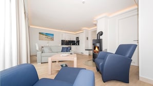 A modern living room with a sofa, a coffee table, and a fireplace.