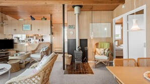 A cozy cabin interior with a kitchen, dining area, and a fireplace. - Beautiful home in Stubbekøbing with WiFi (Stubbekøbing)