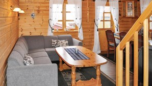 Een gezellig houten interieur met een bank, een tafel en een trap.