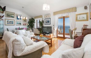 Relax in a stylish living room with a comfortable seating area, flat-screen TV, and beautiful artwork.