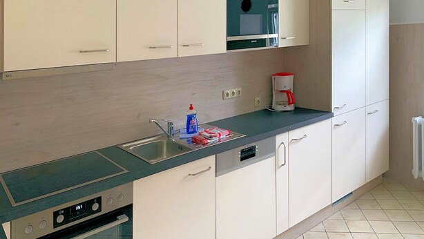 A kitchen with a sink, dishwasher, microwave, and a coffee maker. - Wede, WH - Residential building, Germany (Ückeritz)