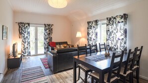 Een zithoek met een tafel en stoelen, een bank en een lamp.