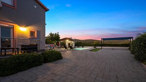 Ein Innenhof mit Pool, Sitzgelegenheiten im Freien und einem überdachten Bereich.