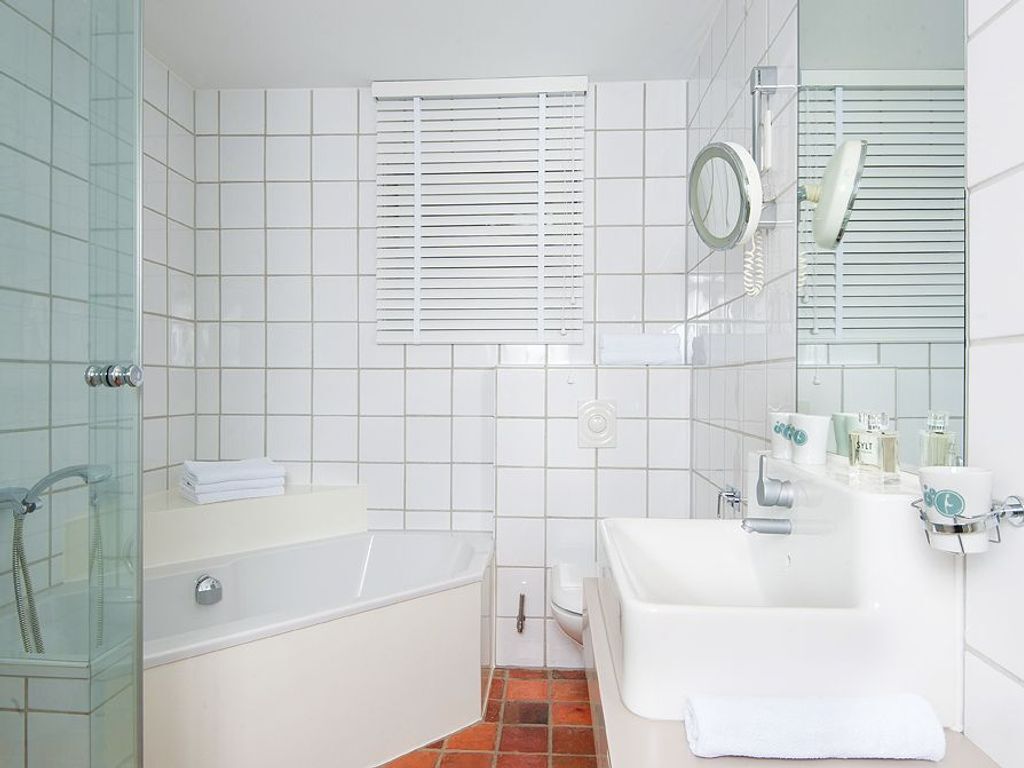 A modern bathroom with a bathtub, a shower, and a sink.