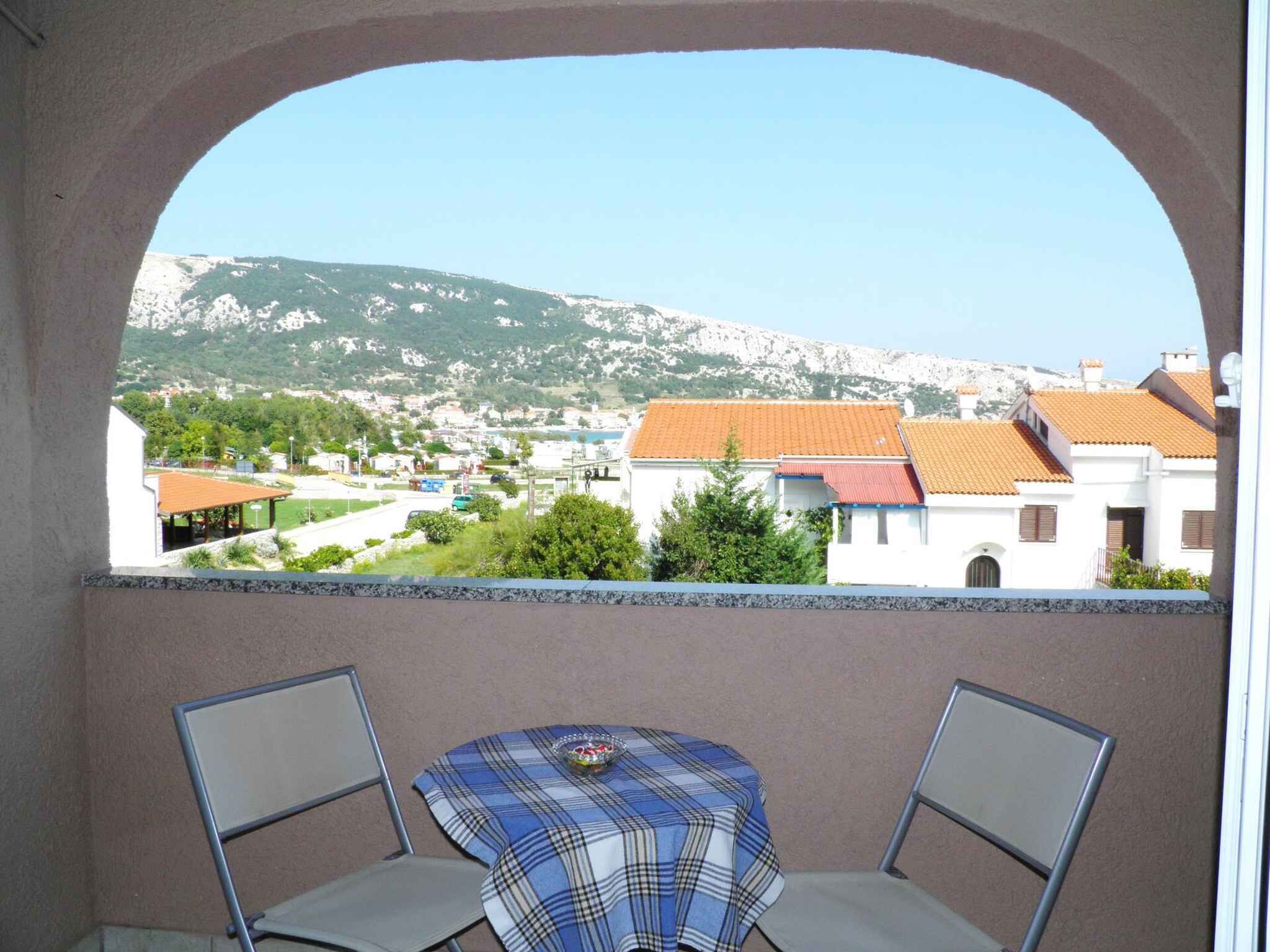 Ein Balkon mit Blick auf eine Stadt und Berge.