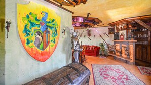 A room with a large shield coat of arms on the wall, a knight statue, wooden furniture, and a rustic interior design. - Gorgeous home in Nordwestuckermark (Nordwestuckermark)