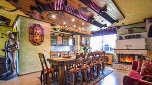 A dining area with a wooden table and chairs, a fireplace, and medieval-themed decor including a knight statue and a clock. - Gorgeous home in Nordwestuckermark (Nordwestuckermark)