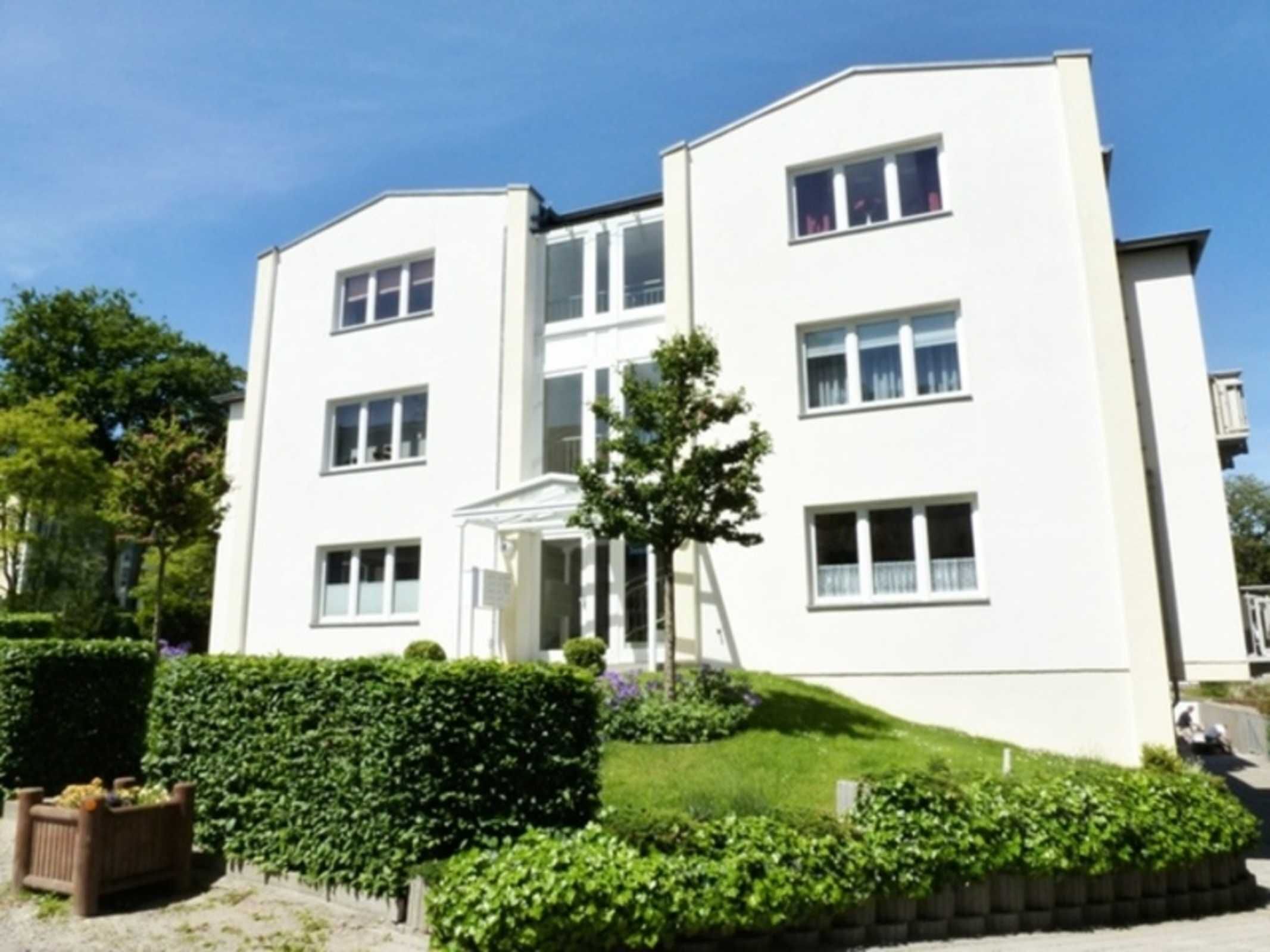 A multi-story building with a symmetrical facade, large windows, and a central entrance with a small porch.