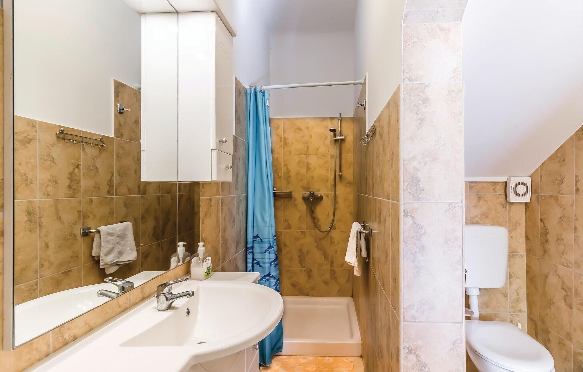A bathroom with a white sink, a bathtub, a toilet, and a shower area.