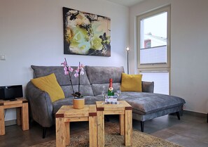 A living room with a grey sofa, wooden coffee table, and a painting on the wall.