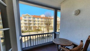Ein Balkon mit Tisch und Stühlen mit Blick auf ein Wohngebiet mit mehrstöckigen Gebäuden.