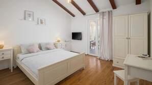 A bedroom with a bed, bedside tables, a TV, a wardrobe, and a desk. - Amazing home in Kranjci (Kranjci)