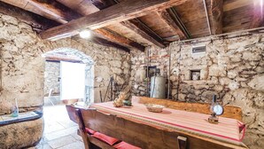 A rustic stone interior with a wooden bench and a table. - Nice home in Moscenicka Draga with WiFi (Moscenicka Draga)