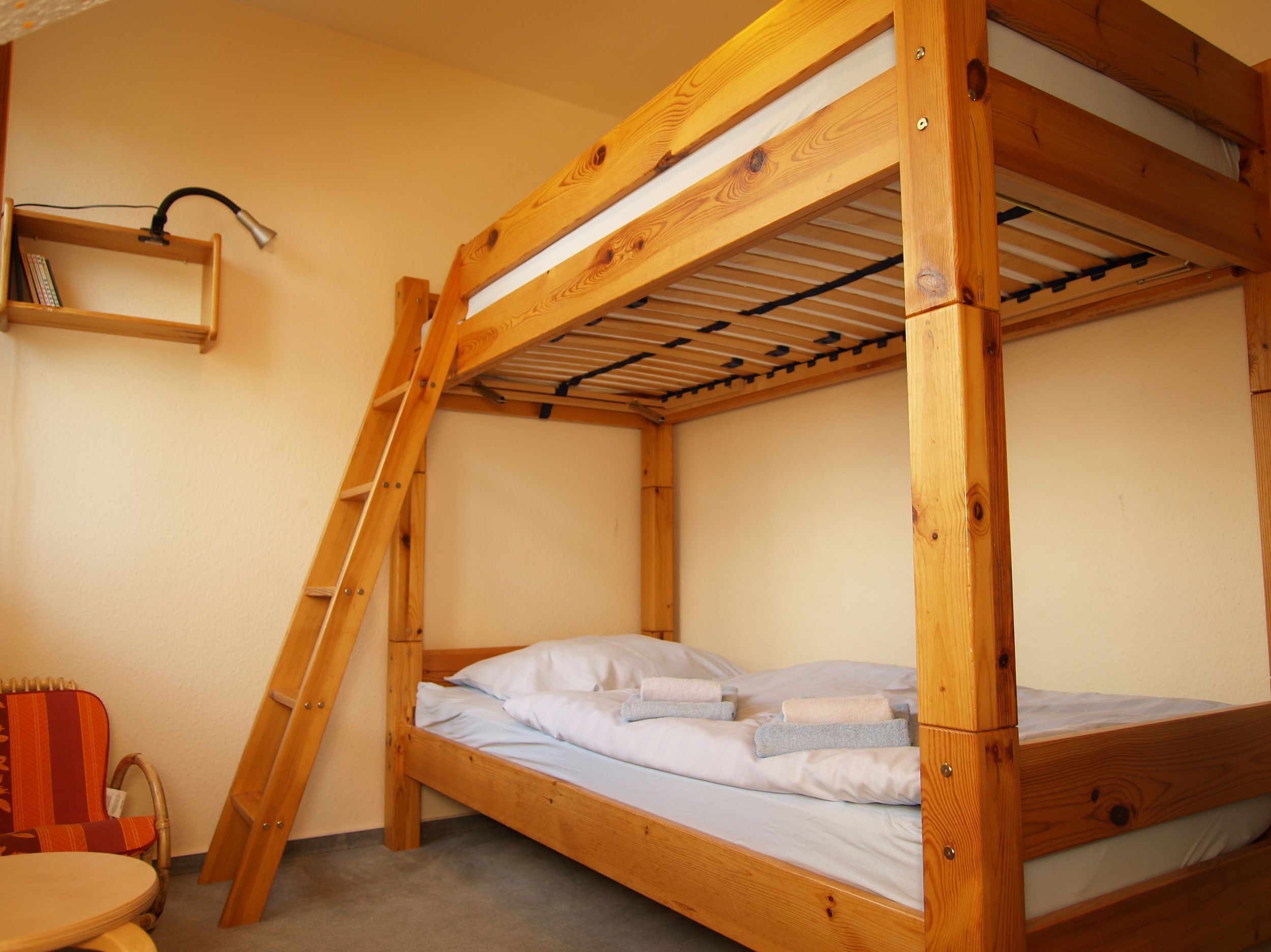 A bunk bed with a wooden frame and a shelf above it.